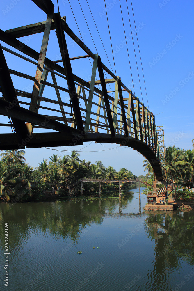An old iron bridge across the beautiful backwaters in Kerala, India.