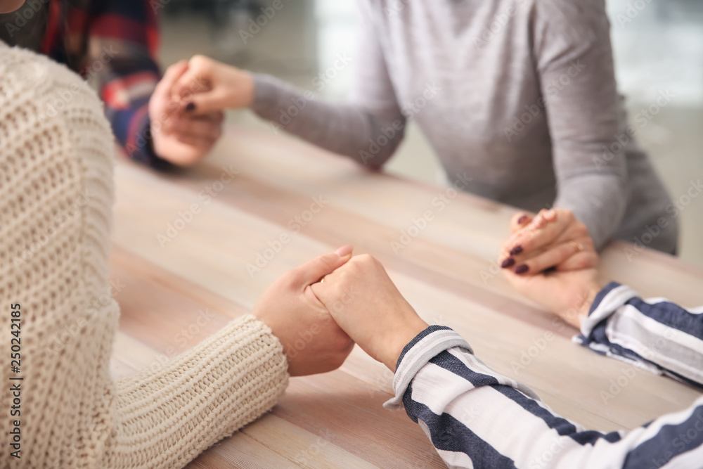 Group of people praying together at table Group of people praying together at table