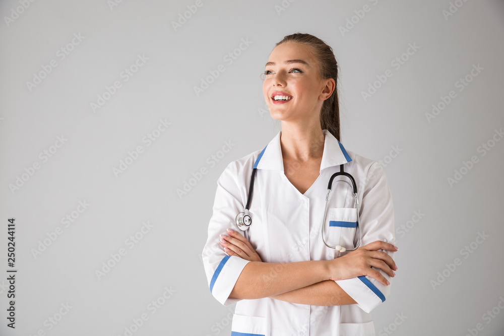 Beautiful young woman cosmetologist doctor isolated over grey wall background. Beautiful young woman cosmetologist doctor isolated over grey wall background.