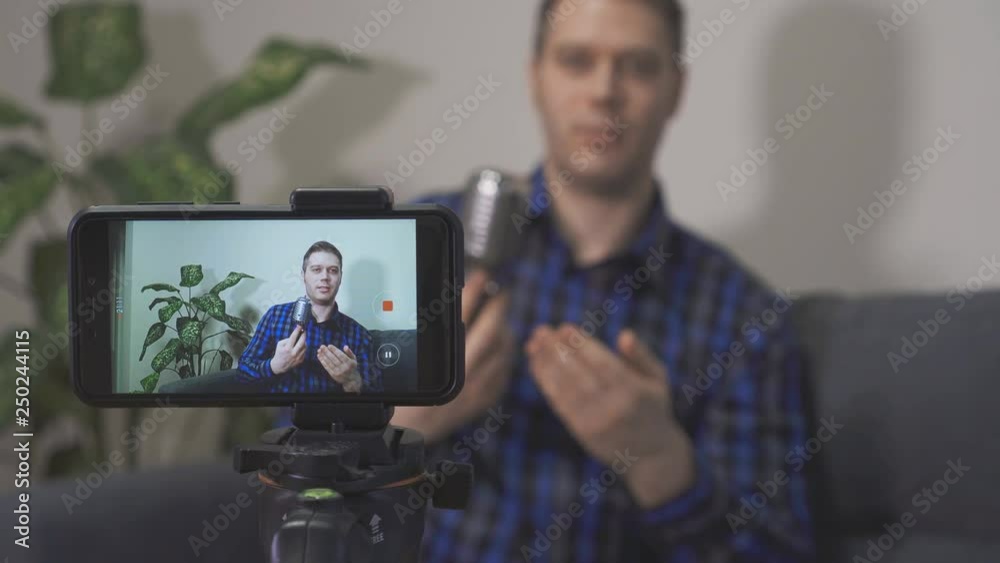 Handsome man making video blog about musical instruments.