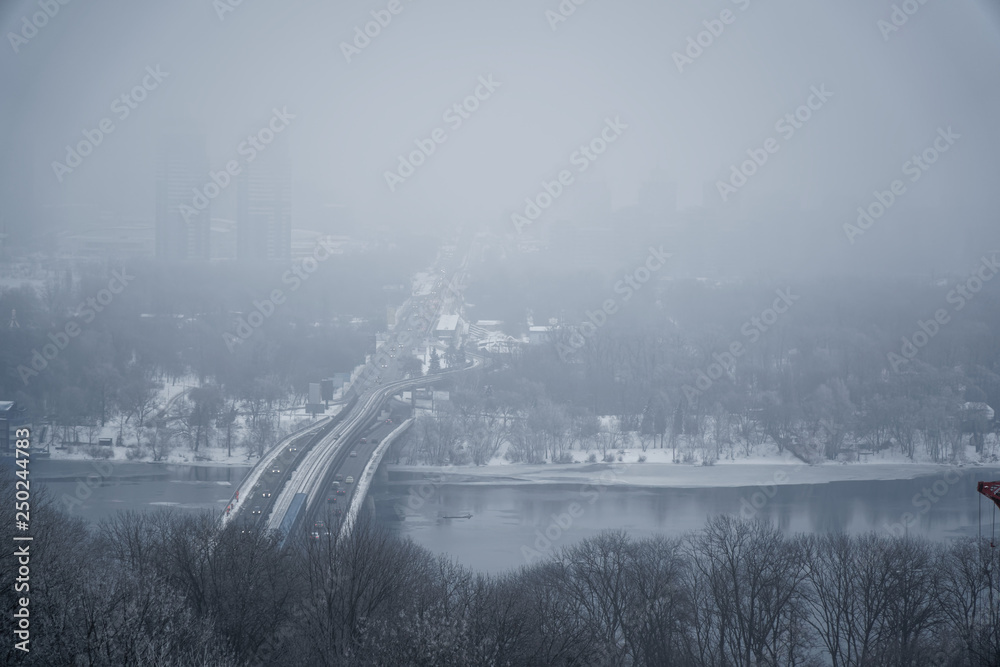 Foggy winter cityscape. Urban landscape, Foggy city street with silhouettes of residential buildings.