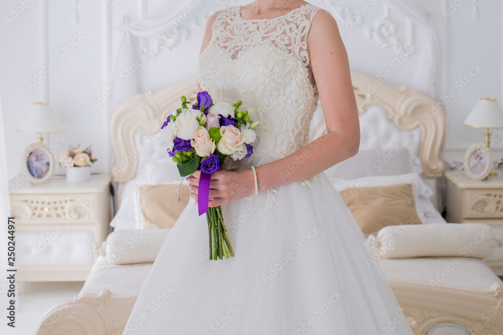 bride holds a wedding bouquet in a bright room bride holds a wedding bouquet in a bright room