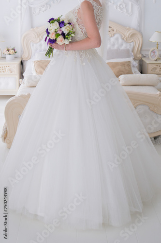 bride holds a wedding bouquet in a bright room © dyachenkopro