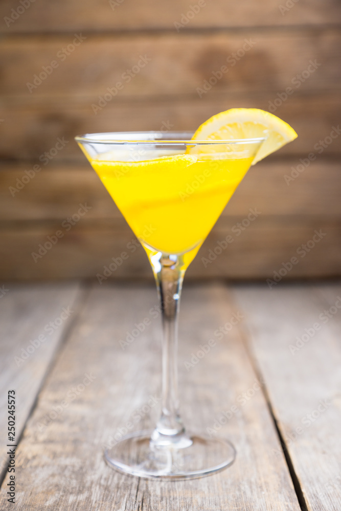 Fresh lemon cocktail in martini glass on the wooden background. Selective focus. Shallow depth of field.