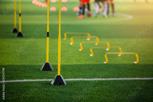 yellow hurdles and ladder drills on green artificial turf