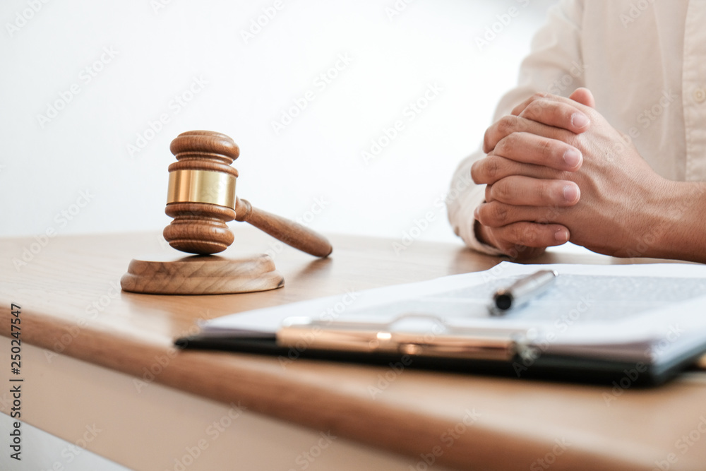 Legal counsel presents to the client a signed contract with gavel and legal law. justice and lawyer concept.