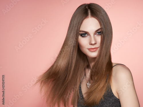 Brown-haired Girl with Long Healthy and Shiny Smooth Hair. Care and Beauty. Beautiful Model Woman Smiling. Make-Up and Jewelry