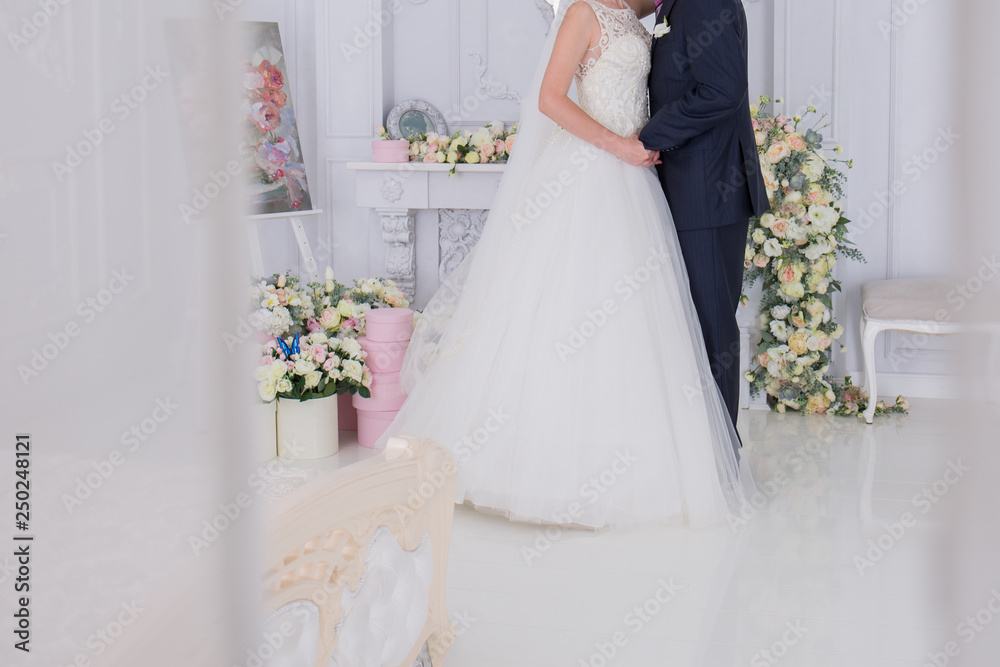bride and groom stand together in a bright room