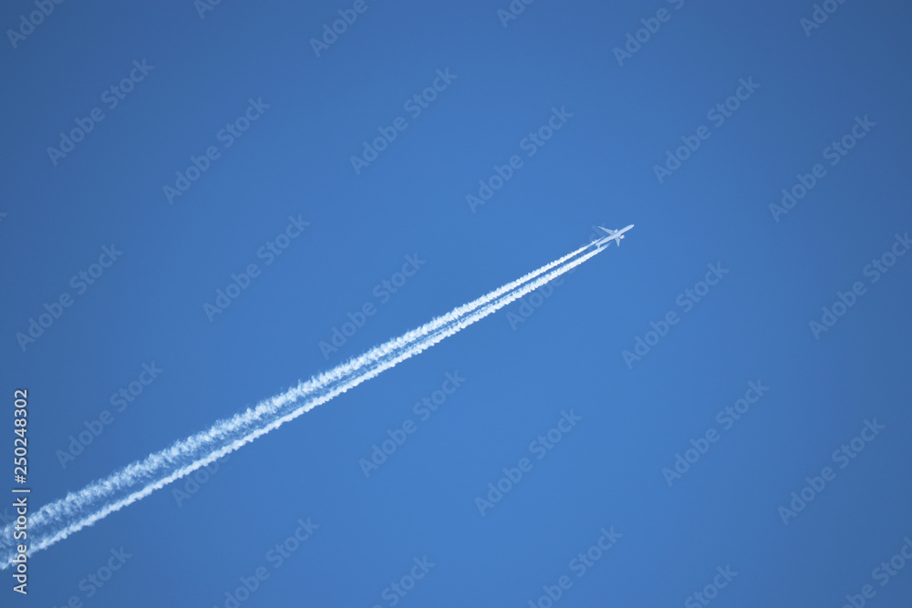 Jet airplane with contrail. Trace of the high flying plane in the clear blue sky Jet airplane with contrail. Trace of the high flying plane in the clear blue sky