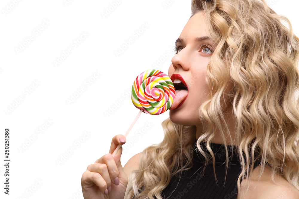 beautiful young girl sexually licks a bright colored candy. Isolated on white background. Copy space