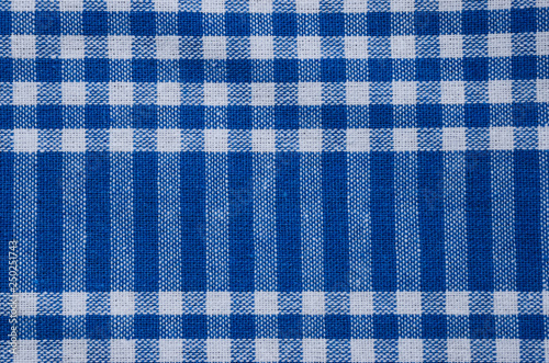 Blue tablecloth, gingham pattern, texture. Textile, checked abstract retro picnic fabric background. 