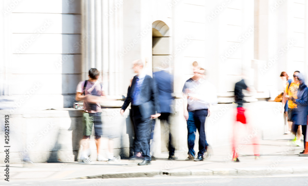 Obraz premium Motion blur of walking people. Modern competitive life concept. People walking next to the Bank of England wall. London, UK