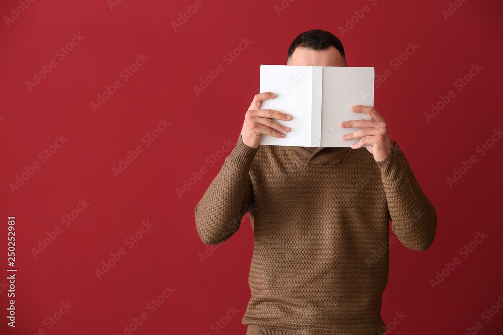Handsome young man with book on color background Handsome young man with book on color background