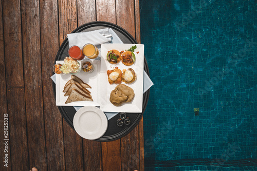 Canvas Print Hombre y chica bebiendo y comiendo en piscina.