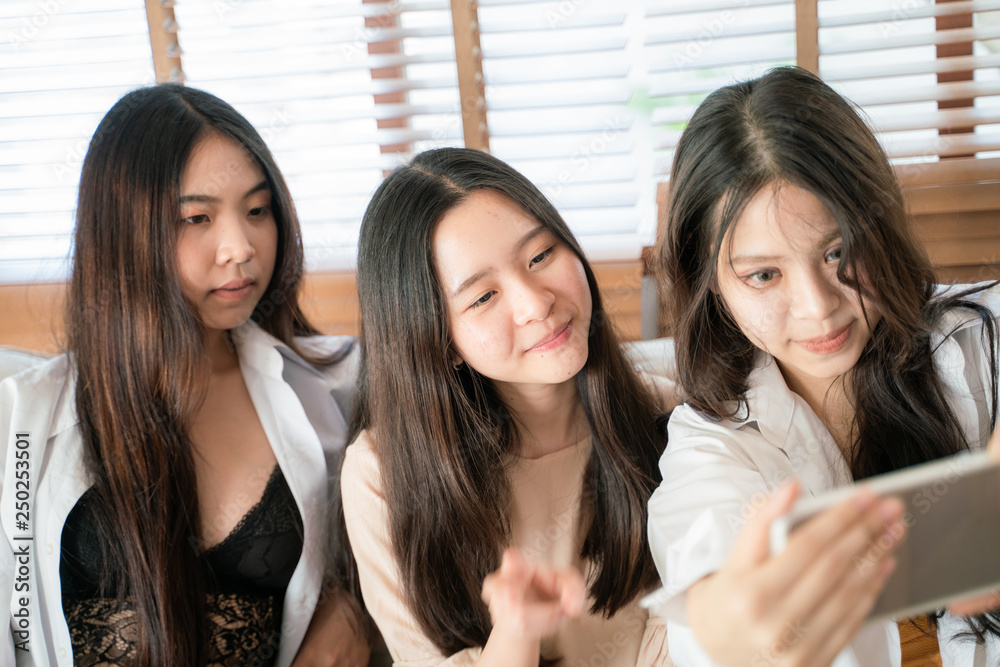 Obraz premium Smiling beautiful asian business women making selfies photo
