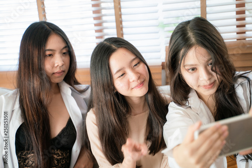 Smiling beautiful asian business women making selfies photo