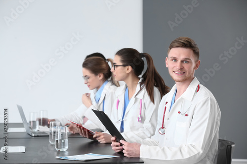 Young doctors sitting at ta...