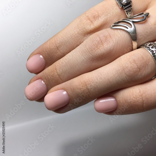 Flesh-colored manicure on nails. Female manicure