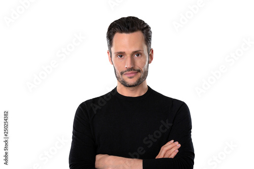 Freundlicher Junger Mann mit verschränkten Armen in einem schwarzen Pullover