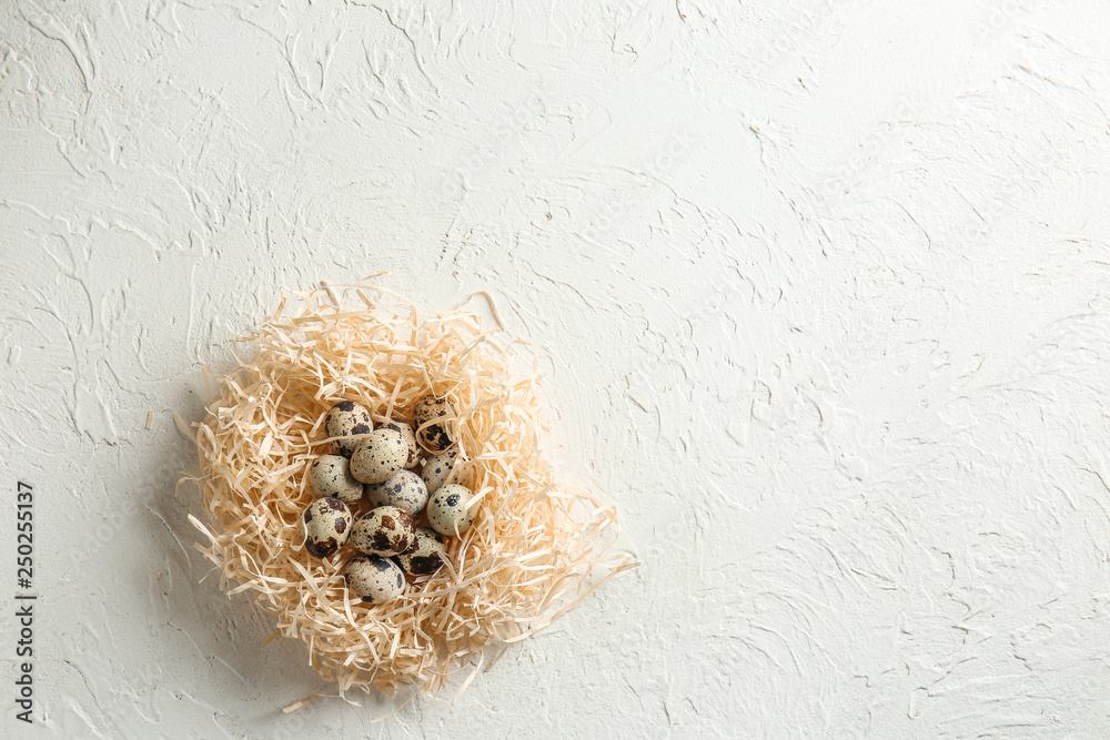 Fototapeta premium Nest with fresh quail eggs on white table