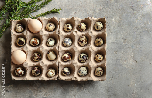 Cardboard holder with fresh quail eggs on table