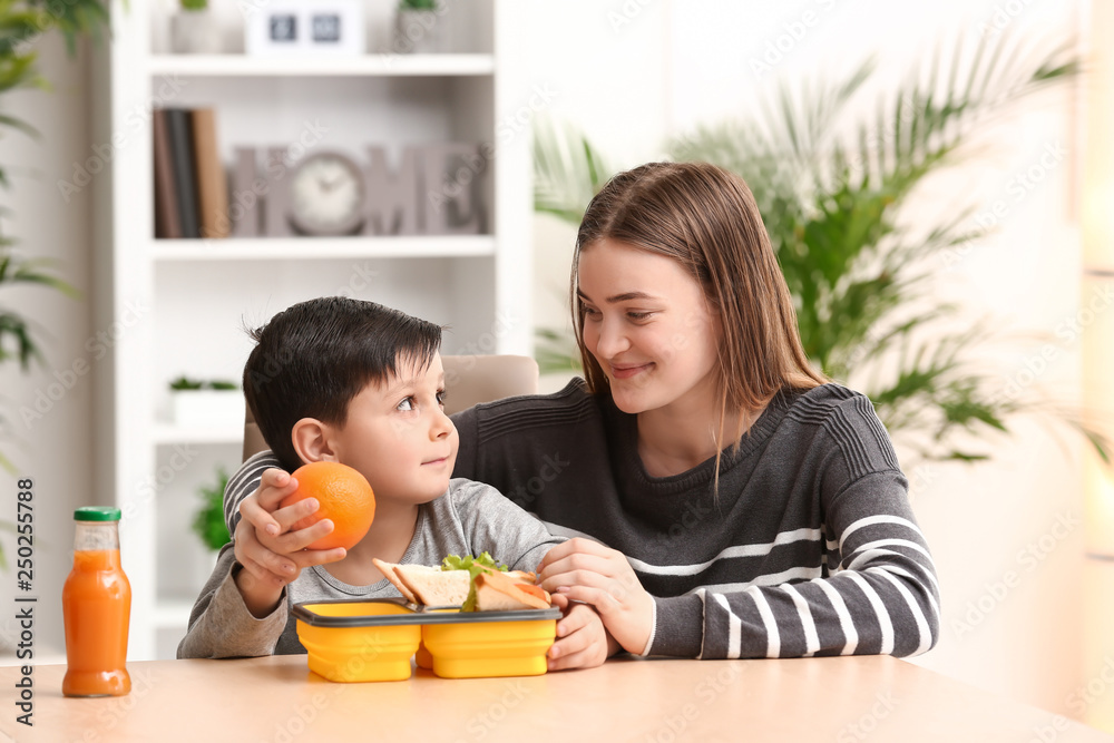 Mother packing school lunch for her little son at home Mother packing school lunch for her little son at home