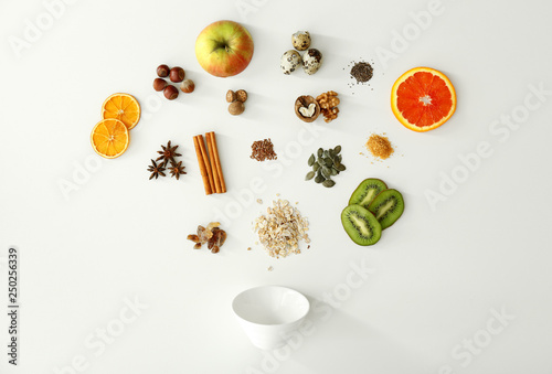 Raw oatmeal, fruits and spices on white background