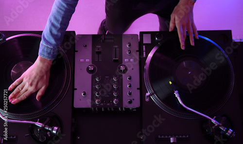 фотографія Female DJ playing music in club, top view