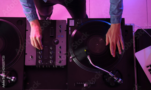 Female DJ playing music in club, top view
