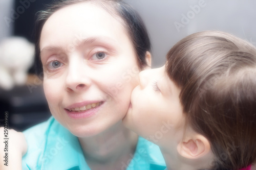 The daughter loves the mother. Daughter gently kisses her mother on the cheek.