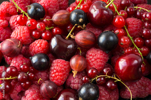 Ripe raspberries, blackcurrants, cherries, red currants and gooseberries. Mix berries and fruits. Top view. Background berries and fruits. Various fresh summer fruits.