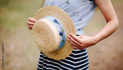 Beautiful woman and boater straw hat with blue decor in summer