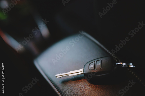 Close up of a car key ring and remote control alarm system charm in vehicle new car interior. soft focus. 