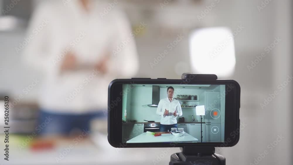 Man on the kitchen filming video. Vlogging concept. Man on the kitchen filming video. Vlogging concept.