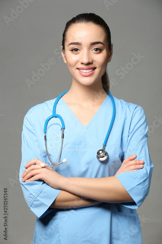 Female doctor on grey backg...
