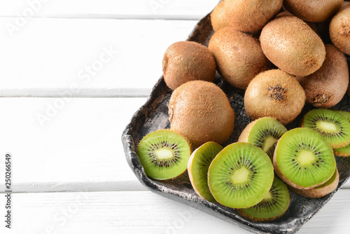 Tray with ripe kiwi on wooden table