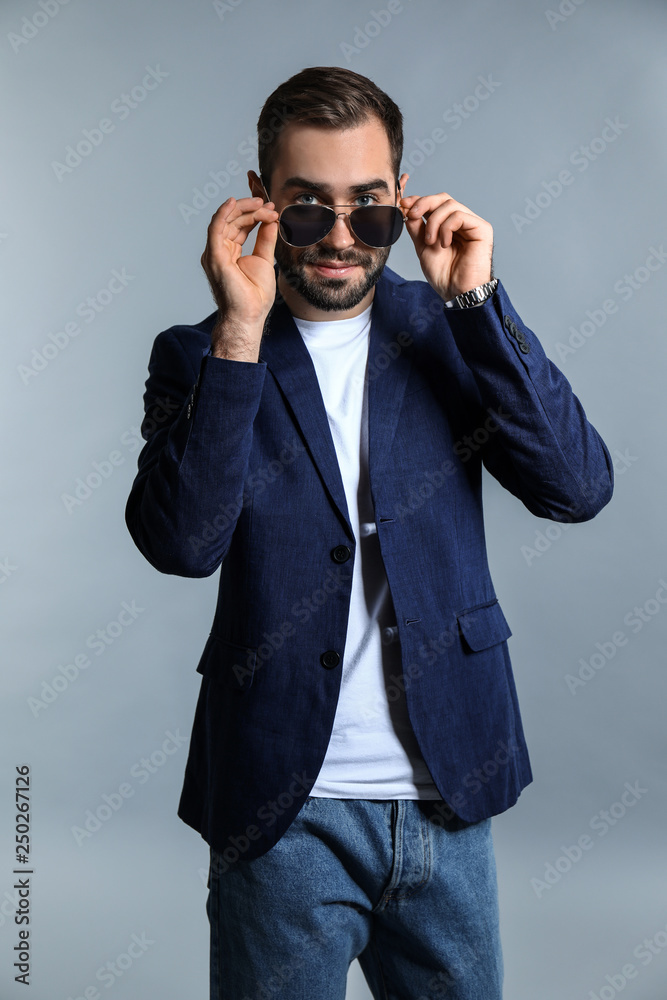 Handsome fashionable man on grey background Handsome fashionable man on grey background