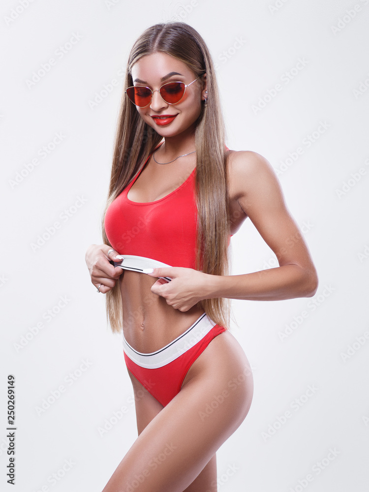 Sexy young model with a perfect body. Girl in red lingerie. Model with a  sports figure in sunglasses. Stylish portrait of a pretty girl with clean  skin. Advertising space. Stock Photo