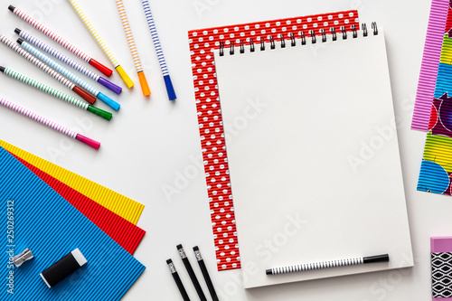 Creative colorful school desk. Top view. Opened empty notebook. Mockup. Colorful school supplies.