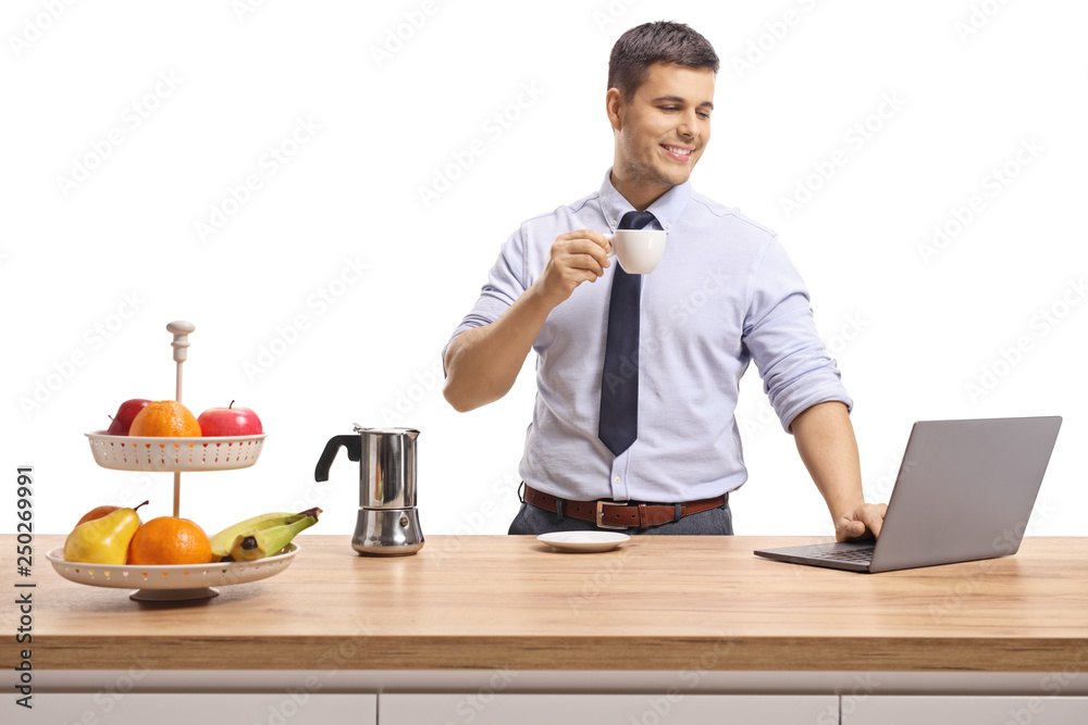 Young man wearing shirt and tie drinking espresso coffee and working on a laptop Young man wearing shirt and tie drinking espresso coffee and working on a laptop