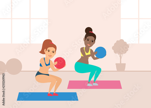 two young women exercising with balls in gym