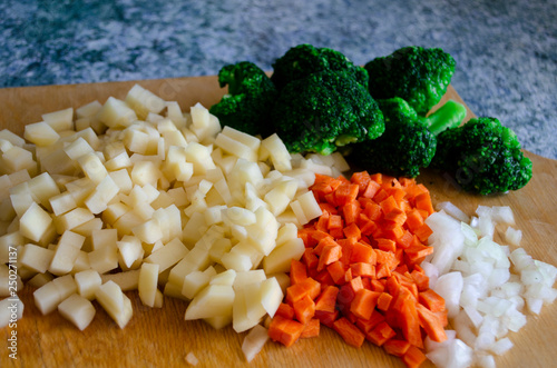 Selection of fresh vegetables including onion, potato, carrot and broccoli.