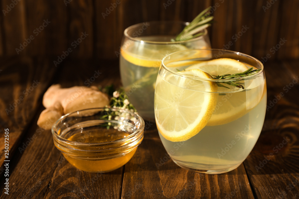 Glasses of fresh lemonade, honey and ginger on wooden table Glasses of fresh lemonade, honey and ginger on wooden table