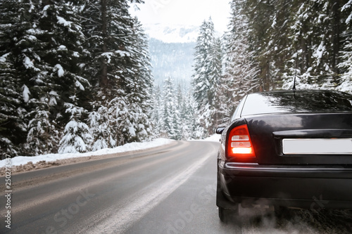 Car on road at snowy winter resort © Pixel-Shot