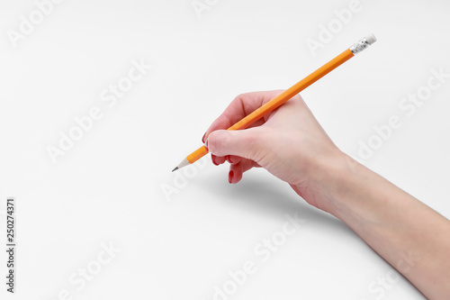 Female hand holding pencil isolated on white background, close-up, cutout, copy space