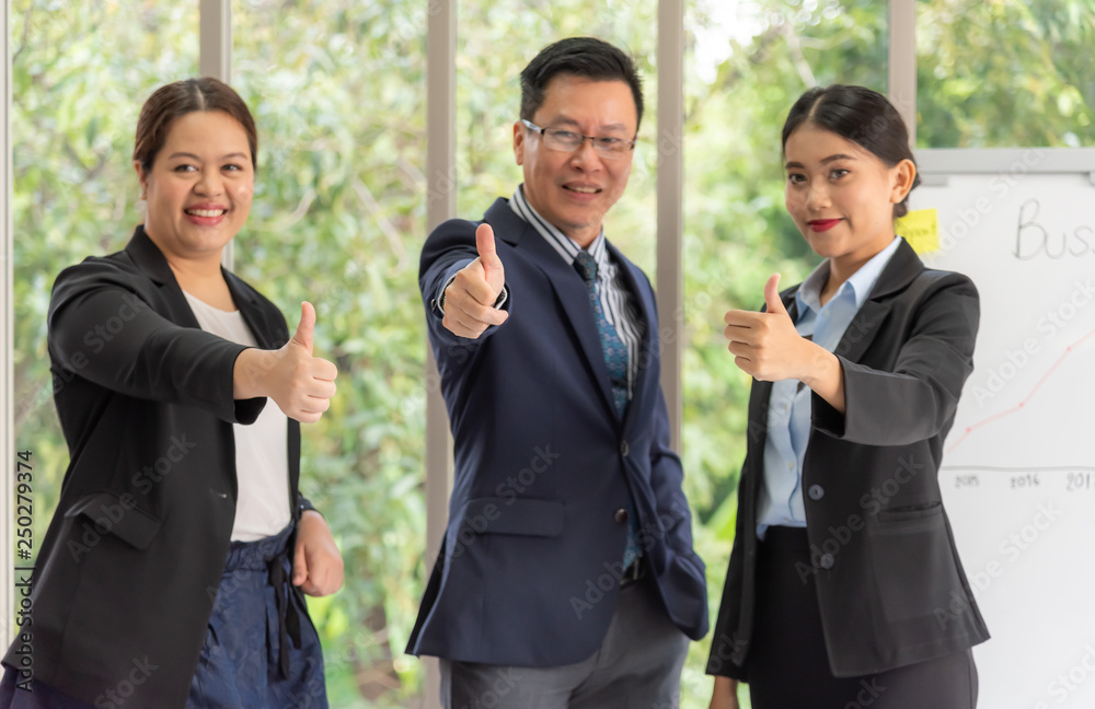 Blurred soft images of Businessmen are smiling and raising hands to make great symbols, because of business successful at workplace with green nature background to business concept. Blurred soft images of Businessmen are smiling and raising hands to make great symbols, because of business successful at workplace with green nature background to business concept.