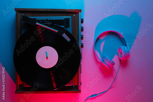 Vinyl player with lp record. Retro wave, neon light, ultraviolet. Nightclub. Top view, minimalism photo