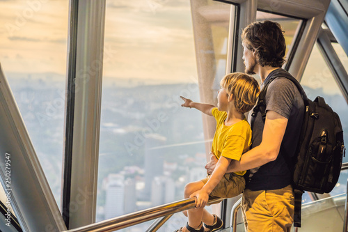 Photography Dad and son are looking at Kuala lumpur cityscape