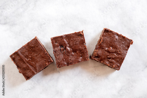 homemade chocolate fudge brownies with pecan nut and dried cranberry on white baking paper background.