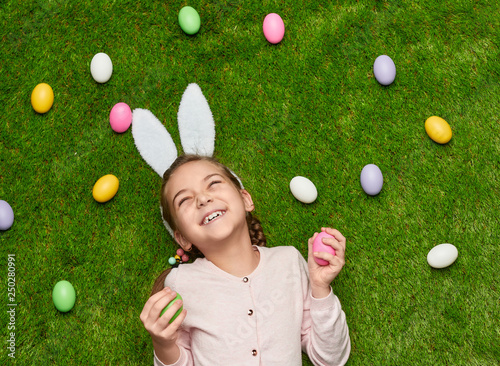 Cheerful girls with Easter eggs on lawn